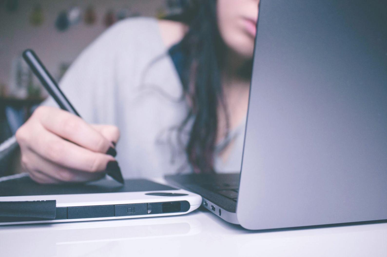 Person reviewing financial documents and planning budget on laptop